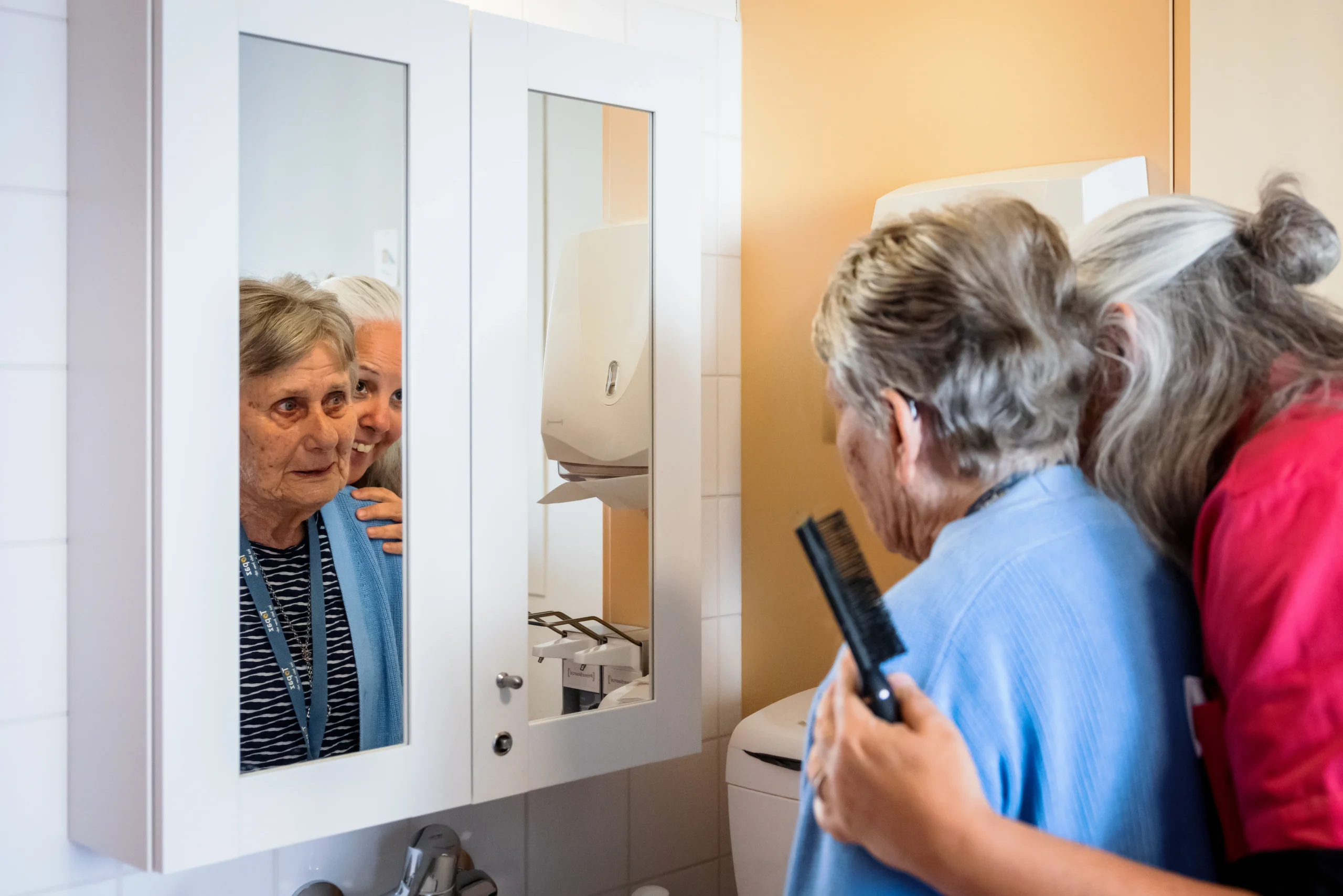 zorgcollega van topaz helpt bewoner met haren kammen