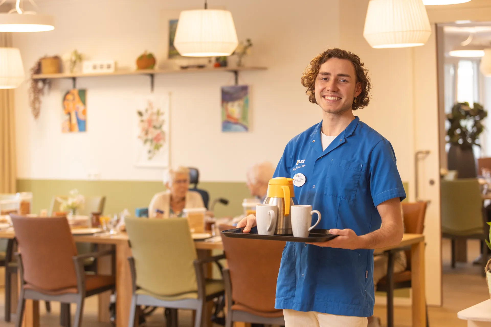zorgmedewerker koffie en thee aan het uitdelen aan de bewoners