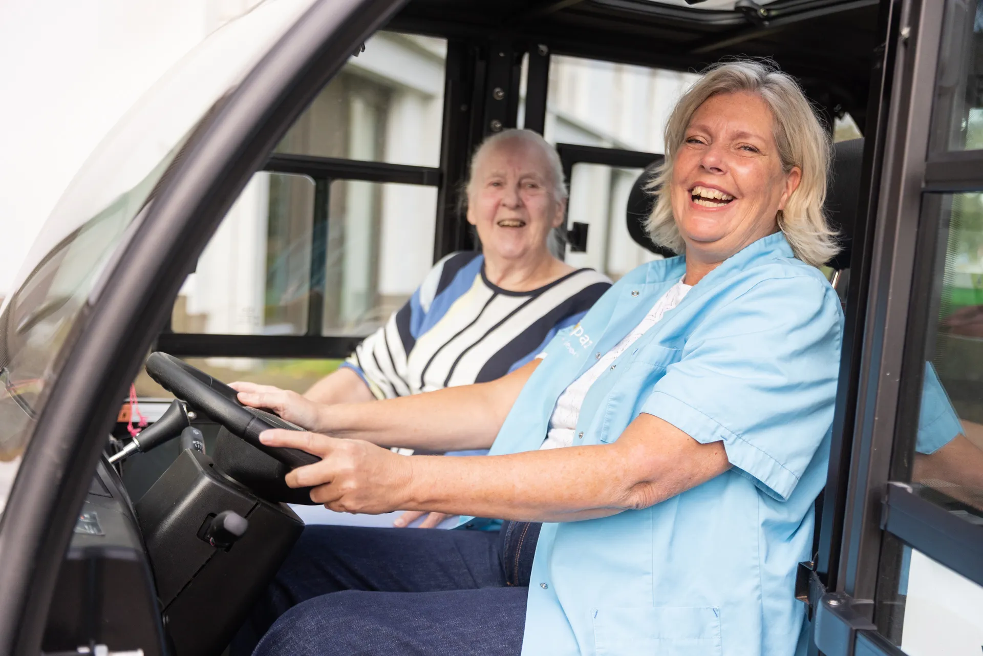zorgcollega van topaz zit met een bewoner in een tuktuk