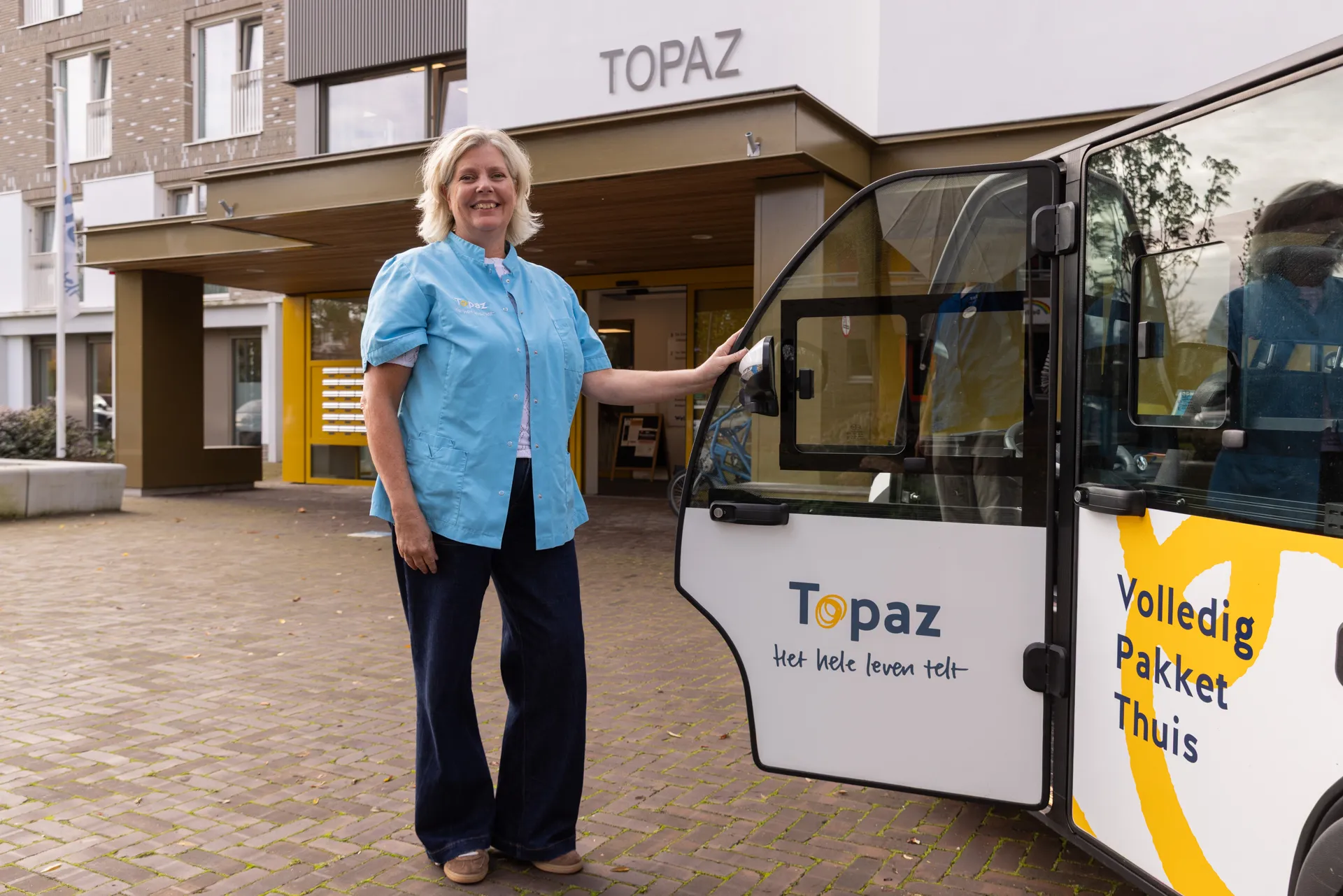 zorgcollega van topaz staat bij de tuktuk van topaz volledig thuis