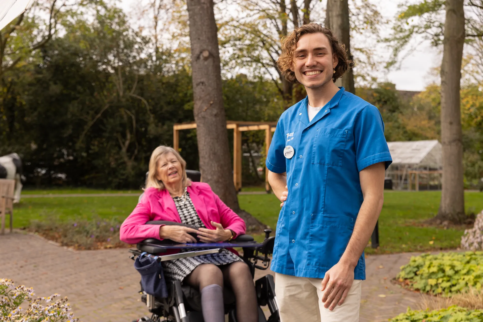 zorgverlener bij topaz lachend in de tuin met bewoner