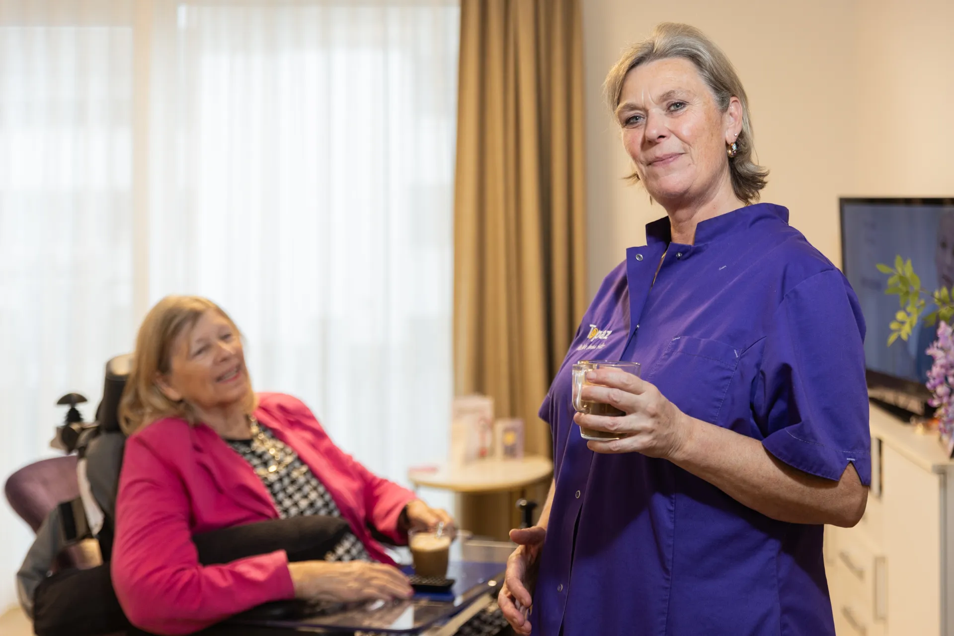 topaz zorgverlener drinkt koffie met bewoner