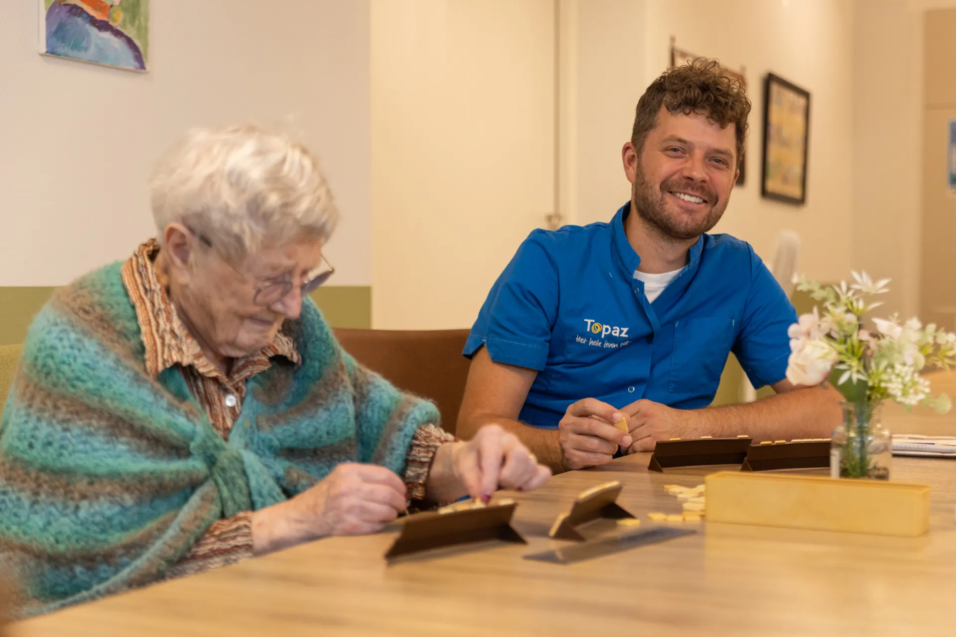 Zorgcollega van Topaz speelt een spelletje met een bewoner