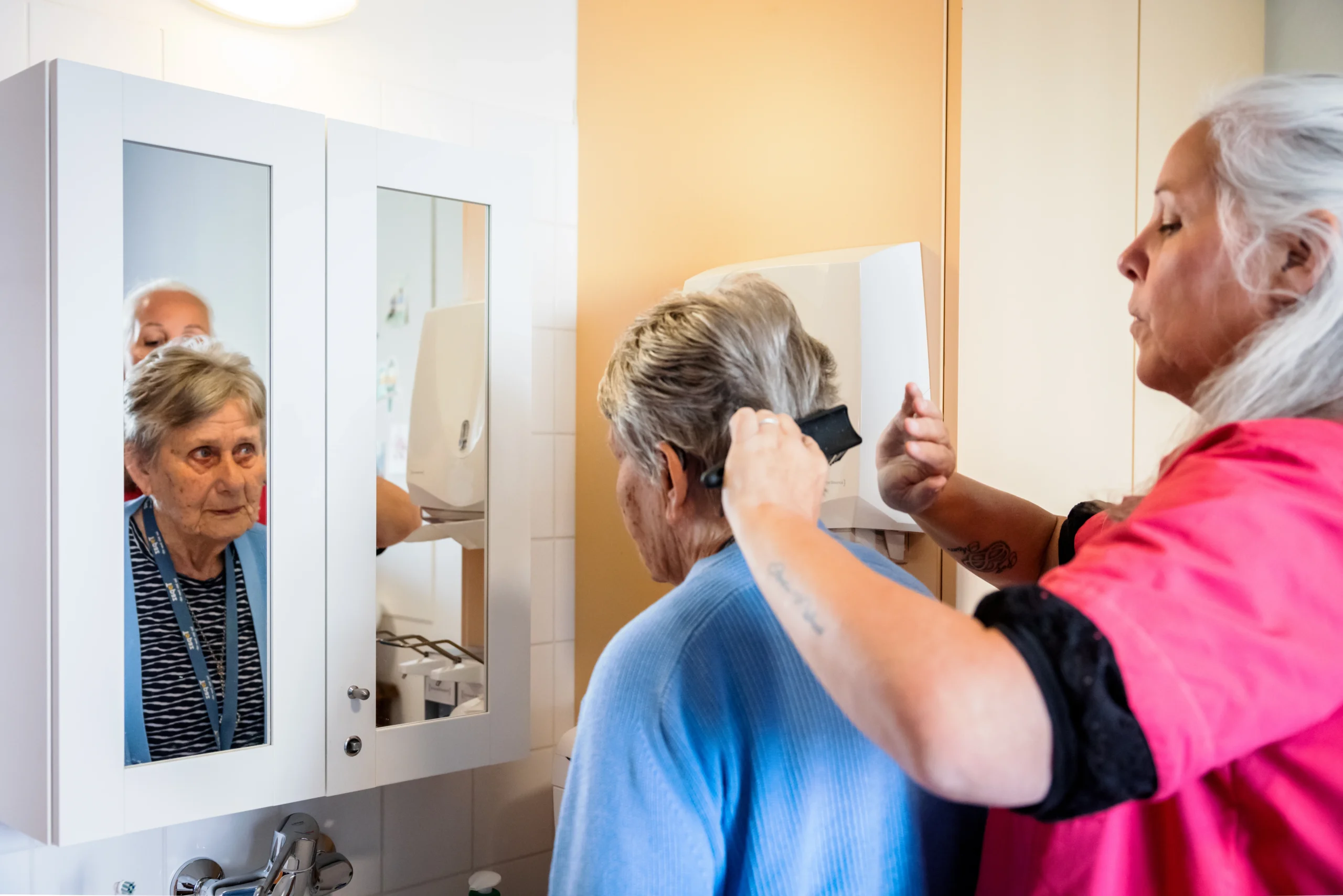 zorg collega van topaz samen met een bewoner voor de spiegel