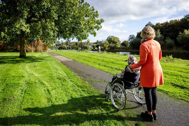 vrijwilliger van topaz aan het wandelen met bewoner
